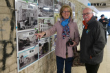 Bridie Casey points to one of her photographs in the exhibition while husband Cllr Charlie Casey looks on. - Opening of Newry Through the Years Subway Gallery