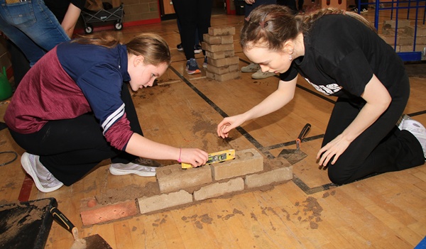 Alexa (left) and Erin (right), use a spirit level to make sure their bricks are perfectly positioned.
