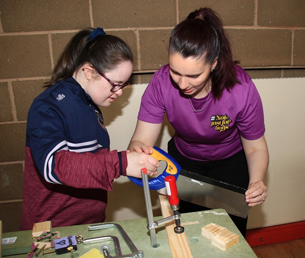 Nadine Gollogly (right) coaches Eva (left), a Key Stage Four student at St Paul’s Bessbrook, as she cuts wood for her brand-new key ring. 