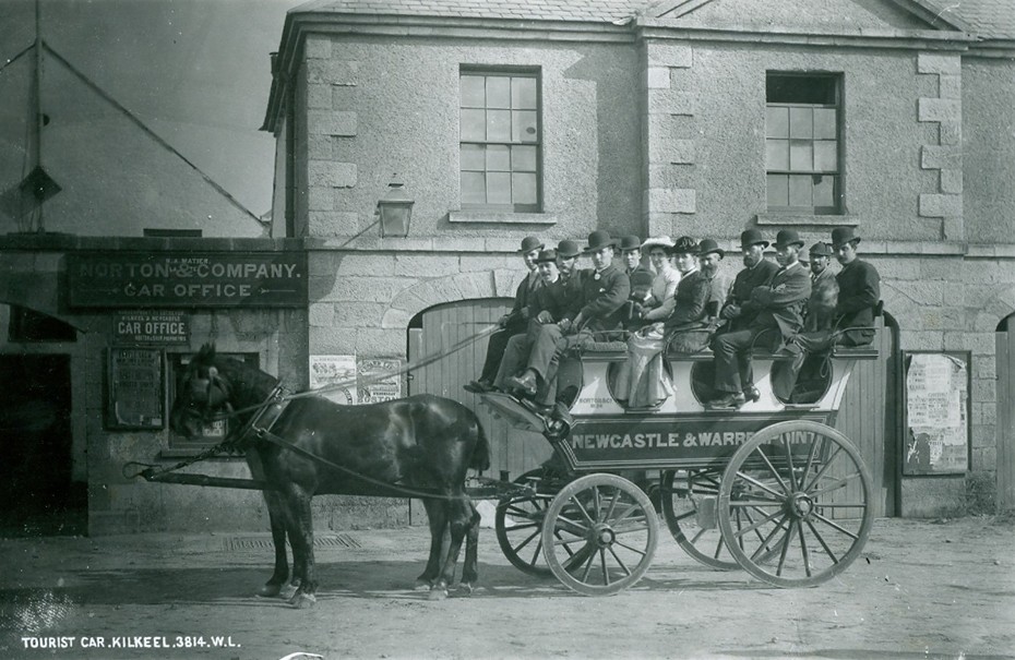 Photograph of a Norton & Co. “Long Car” outside the Courthouse in Kilkeel, c.1887. The open-air service operated along the coastal route between the business’ hotels in Newcastle and Rostrevor. Newry & Mourne Museum, Irvine Collection