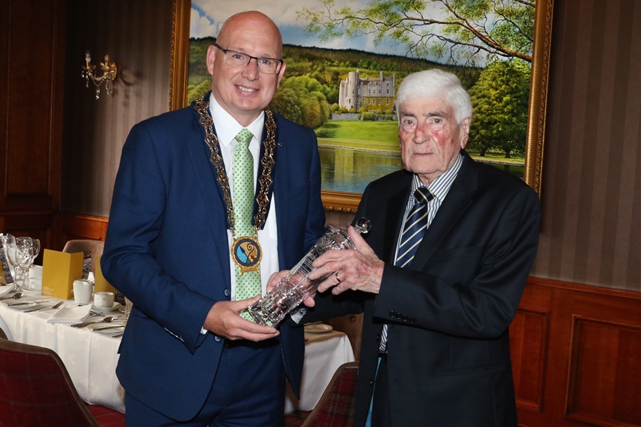 Former SDLP council chairperson Michael Savage presents a retirement crystal to Dermot Curran in 2023.