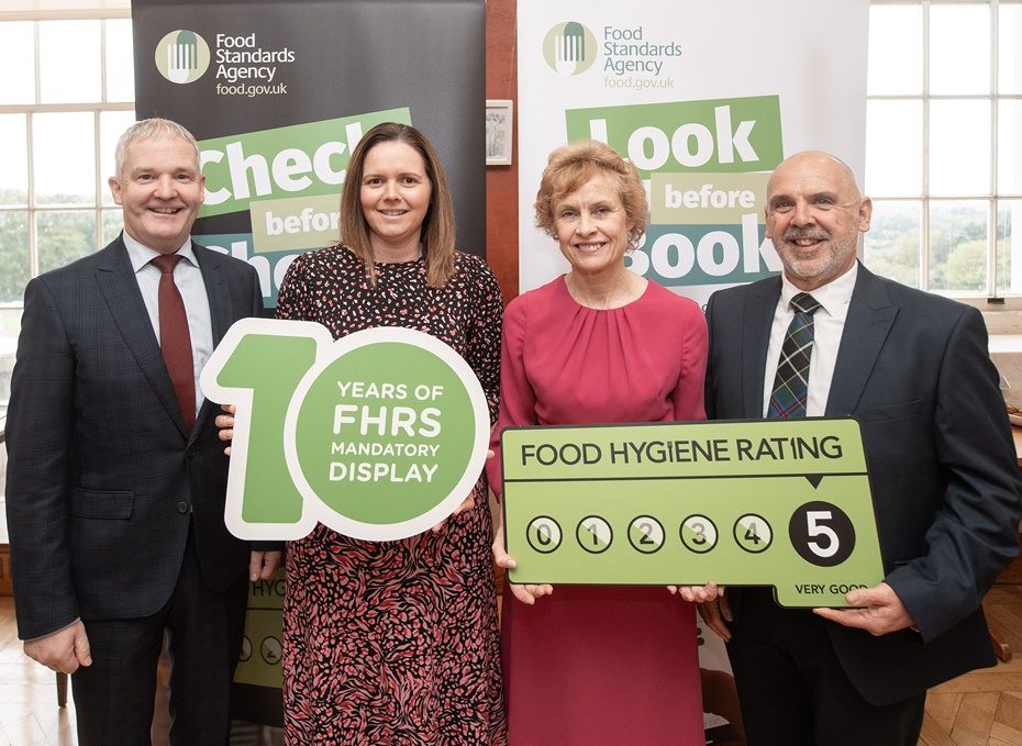 Newry, Mourne and Down District Council environmental health officers Sarah Davidson (second left) and Graham Farthing (right) at the celebration event at Parliament Buildings marking the 10th anniversary of the Food Hygiene Rating Scheme (FHRS), with Andy Cole (NI Food Standards Agency Director) and Food Standards Agency Chairperson Professor Susan Jebb.