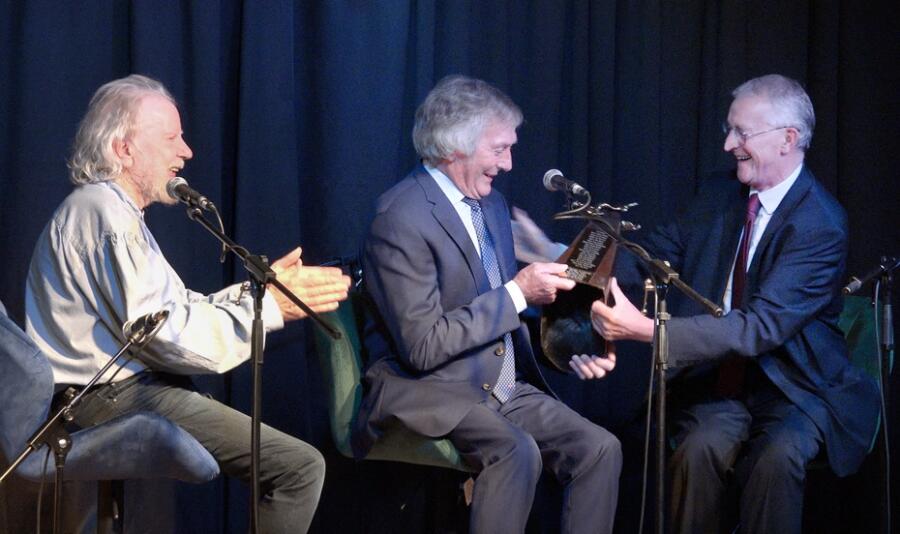NI Secretary of State Hilary Benn presents Pat Jennings with the Fiddlers Green Music of Healing  Creative Arts Award while looking on is Tommy Sands.