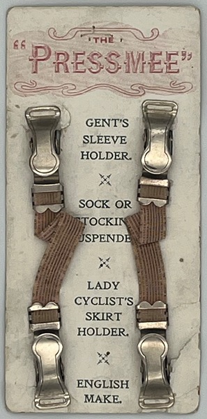 The ‘Press Mee’ Double-Ended Suspender, c.1920 A versatile accessory used as a gentleman’s sleeve holder, sock or stocking suspender, or as a skirt holder for lady cyclists. This example comes from R. J. Sloane’s shop on Newry Street, Kilkeel. Robert James Sloane, originally from Ballykeel West near Rathfriland, County Down, trained in drapery at Foster & Co in Newry before opening his own shop in 1887. By 1895, he had expanded to larger premises, offering high-quality clothing and fashion accessories for both ladies and gentlemen. Newry and Mourne Museum Collection