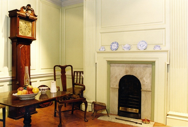 Museum display in Newry Arts Centre, showing a longcase clock made by John Gelston, dining chairs from Dromalane House and a fold-over table from the reign of George IV. These are all still on display in Gallery 2. Newry & Mourne Museum Collection 
