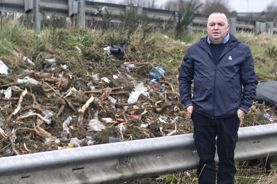 Cllr Aidan Mathers points out some of the litter at the side of the A1