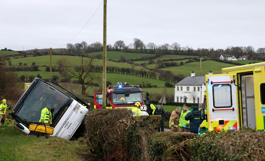 The school bus sits on its side at the scene on the Tullyah road. Photograph: Noel Moan/ Newry Democrat