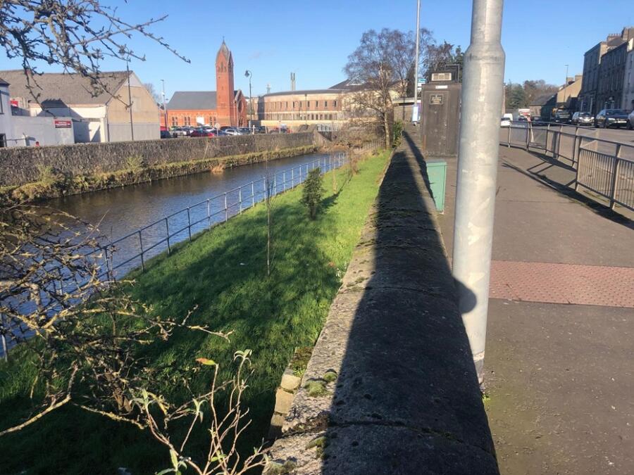 The grassy area to the right of the river denoted where the Mill Race once openly flowed. Photograph taken by the author.