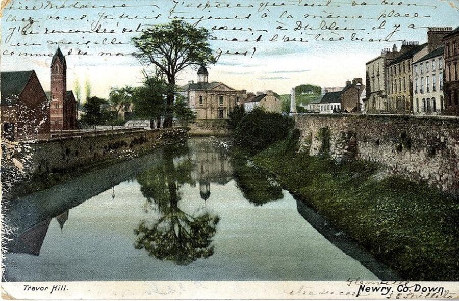 Postcard titled ‘Trevor Hill, Newry, Co. Down’, looking along the Clanrye River towards the Courthouse and Riverside Reformed Presbyterian Church. The postcard has a Newry postmark, the address in French is Lausanne, Switzerland. Newry & Mourne Museum Collection