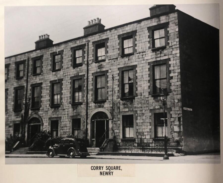 Black and white mounted photograph of Corry Square, Newry, 1944. Shows the premises that were formerly the Infantry barracks in the (1790’s) and Constabulary barracks (1856-66). Newry & Mourne Museum Collection