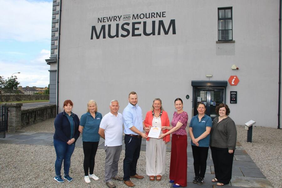 NMDDC Deputy Chairperson, Councillor Geraldine Kearns accepts the award of full Museum Accreditation by Northern Ireland Museums Council (NIMC) as part of the UK Museum Accreditation Scheme, from Eva Lynch, Development Officer for NI Museums Council. Also included are from left: Dympna Tumilty and Therese McCaul, Museum Assistants; Declan Carroll, Education and Outreach Officer; Alan Freeburn, Museum and Heritage Manager; Joanne Glymond, Museum Assistant and Joanne Cummins, Collection Officer.