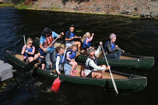 Boys and girls learning the skill of paddling a canoe at the Water Festival.