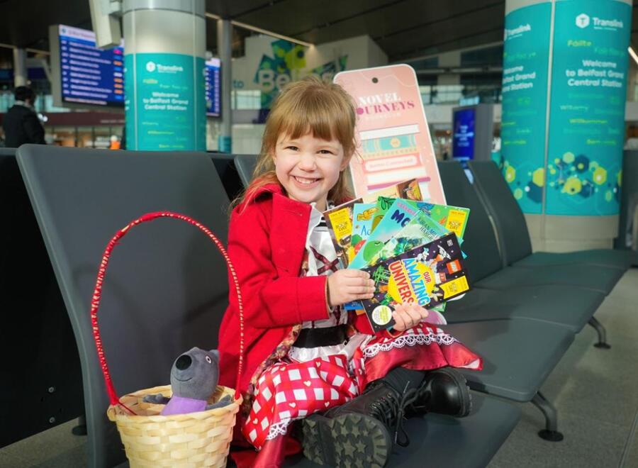 Scarlett, 4, helps Translink mark World Book Day with 300 children's books available for young passengers. 