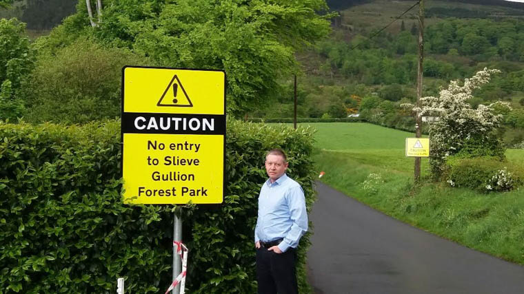Cllr Mickey Larkin at one of the new signs on Wood Road.