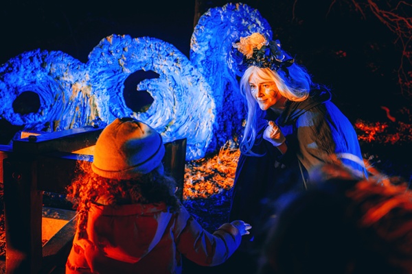Excited children meet costumed characters, illuminated by light displays in Slieve Gullion Forest Park.