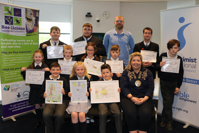 Prizewinners in the Bee Aware Poster Competition back row l-r Cameron Magee Knockevin School, Commended Artwork Spot Prize, Danan Small Knockevin School, Most Professional Spot Prize, Michael McKinney Biodiversity Officer Newry, Mourne and Down District Council, Dillon Heaney Knockevin School, Beautiful Artwork Spot Prize, middle row Anna-Rae Morrison Downpatrick Primary School, Most Informative Spot Prize, Charlie Stocking Commended for Accuracy, Olivia Brown Downpatrick Primary School Highly Commended, Carl Casement Downpatrick Primary School, Commended Artwork Spot Prize, Neil Holmes Funniest Poster Spot Prize, front row l-r 3rd prize awarded to Caolan Reid Cumran Primary School, 2nd prize awarded to Rose Leanne Gray Downpatrick Primary School, 1st prize awarded to Charlie Muir Cumran Primary School, President Soroptimist International Downpatrick and District Melanie Douglas who presented the awards for the Bee Aware Poster Competition. Prizewinners in the Bee Aware Poster Competition back row l-r Cameron Magee Knockevin School, Commended Artwork Spot Prize, Danan Small Knockevin School, Most Professional Spot Prize, Michael McKinney Biodiversity Officer Newry, Mourne and Down District Council, Dillon Heaney Knockevin School, Beautiful Artwork Spot Prize, middle row Anna-Rae Morrison Downpatrick Primary School, Most Informative Spot Prize, Charlie Stocking Commended for Accuracy, Olivia Brown Downpatrick Primary School Highly Commended, Carl Casement Downpatrick Primary School, Commended Artwork Spot Prize, Neil Holmes Funniest Poster Spot Prize, front row l-r 3rd prize awarded to Caolan Reid Cumran Primary School, 2nd prize awarded to Rose Leanne Gray Downpatrick Primary School, 1st prize awarded to Charlie Muir Cumran Primary School, President Soroptimist International Downpatrick and District Melanie Douglas who presented the awards for the Bee Aware Poster Competition.