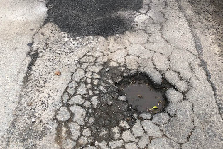 A pothole is repaired while one beside it is left! A pothole is repaired while one beside it is left!