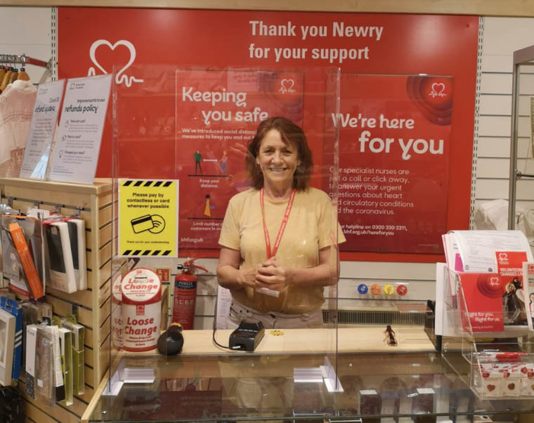BHF NI staff member Ann behind the newly adapted counter after the reopening of the Newry shop