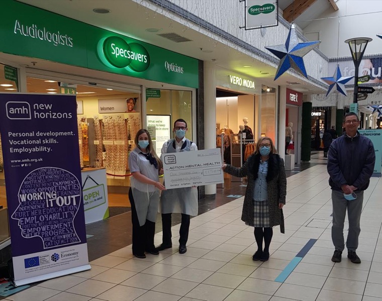 Staff from Specsavers Newry present representatives from Action Mental Health with a cheque for £1170.