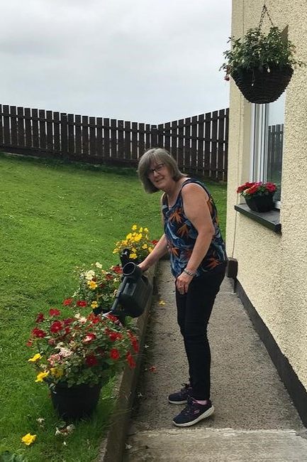 Valerie tends to her garden plants.
