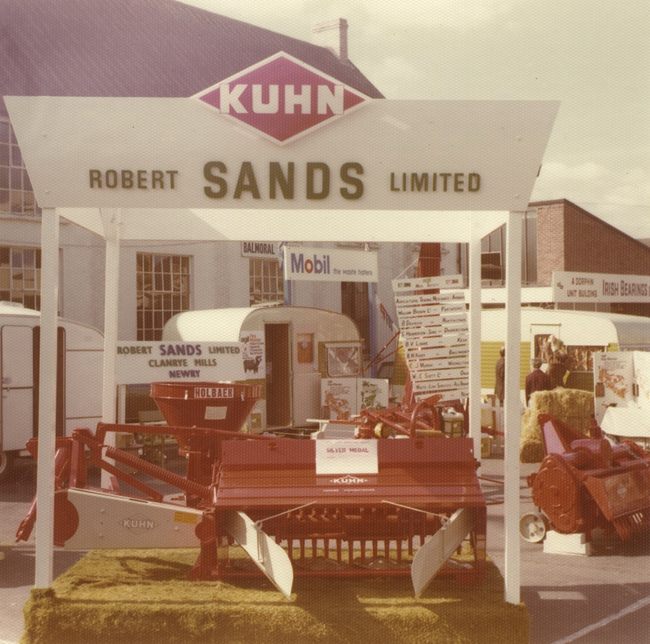 A mower conditioner displayed by Robert Sands Ltd at the Royal Ulster Agricultural Society’s annual show at Balmoral, Belfast in May 1975. This machine was used for harvesting grass crops, which cuts the crop and treats it to speed up the drying process. Newry and Mourne Museum Collection A mower conditioner displayed by Robert Sands Ltd at the Royal Ulster Agricultural Society’s annual show at Balmoral, Belfast in May 1975. This machine was used for harvesting grass crops, which cuts the crop and treats it to speed up the drying process. Newry and Mourne Museum Collection