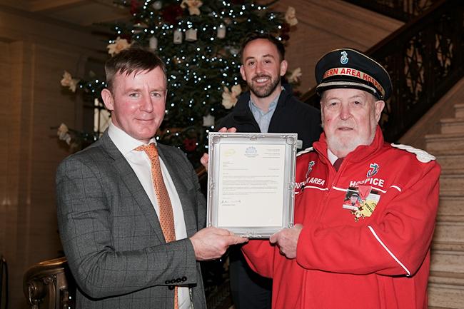 Newry and Armagh MLA Justin McNulty makes a presentation to John Dalzell at Stormont to mark his 30 years of fundraising for the Southern Area Hospice. Also pictured is James McCaffrey, Fundraising Officer, Southern Area Hospice. Photograph: Columba O'Hare/ Newry.ie
