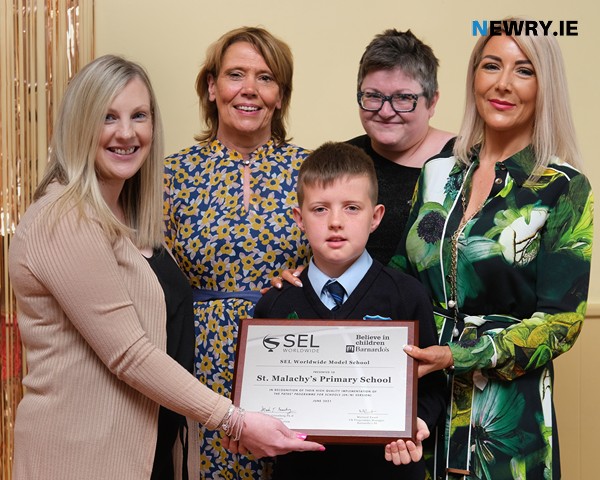 St Malachy's Primary School P7 pupil, Declan Doran pictured with the PATHS Model School award/ Also included are from left: Mairead Ewart, PATHS Programme Director; Kate Carragher, Vice Principal; Martina Luiten, Programme Co-Ordinator , Barnardo's and Mary Creegan, Principal.