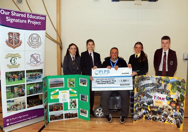 Included from left are: Dani Graham, Newry High School; Lottie Jones, Newtownhamilton High School; Jessica Murray, St. Joseph's High School Crossmaglen and Shea Loughran, St. Paul's High School Bessbrook present Padraig Harte Fundraising, Marketing and Communications Manager P.I.P.S. Hope and Support Charity with a cheque to the value of £1,500 which they raised during their recent Shared Education Signature Project fundraising Colour Run. Included from left are: Dani Graham, Newry High School; Lottie Jones, Newtownhamilton High School; Jessica Murray, St. Joseph's High School Crossmaglen and Shea Loughran, St. Paul's High School Bessbrook present Padraig Harte Fundraising, Marketing and Communications Manager P.I.P.S. Hope and Support Charity with a cheque to the value of £1,500 which they raised during their recent Shared Education Signature Project fundraising Colour Run.