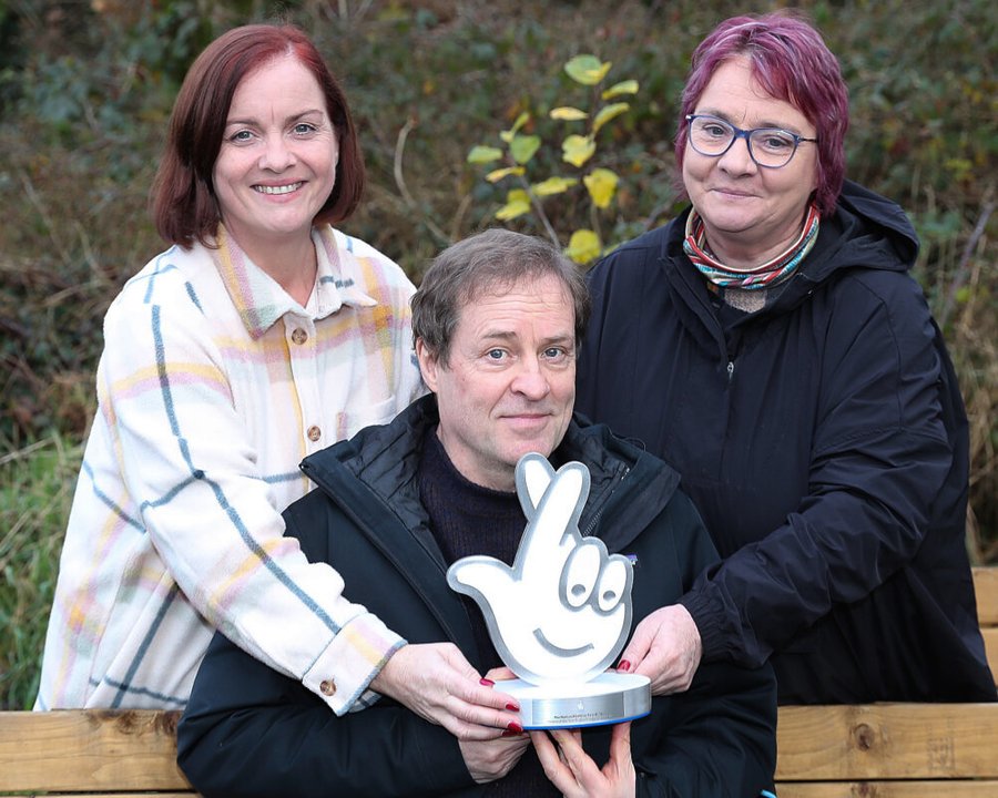 Ardal O’Hanlon presenting Margaret Finnegan and Kathleen Finnegan-Agnew from An Tobar with their National Lottery Award