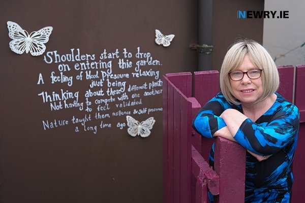 Ann Blair with her poem imortalised on her wall.