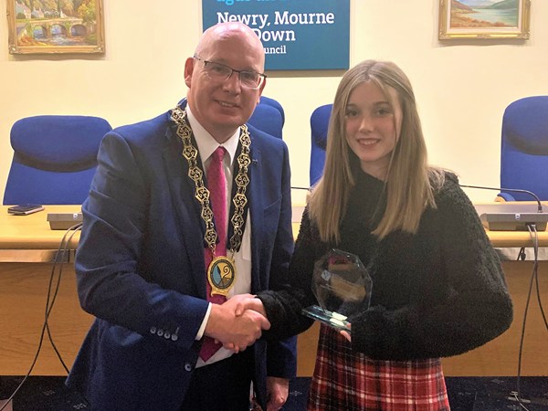 Newry, Mourne and Down District Council Chairperson, Councillor Michael Savage presents Niamh Noade with an inscribed crystal plaque on behalf of the Council to acknowledge  her achievements in the Junior Eurovision Éire 2022 competition.