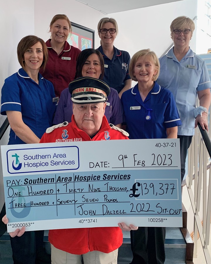 John Dalzell OBE presenting his final cheque to nursing staff at Southern Area Hospice.
