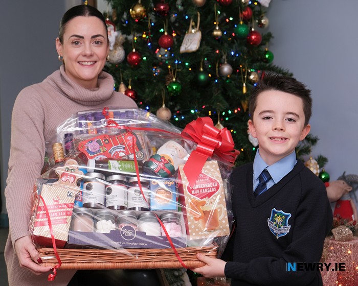 The first prize Christmas Hamper in the Christmas Draw at St Malachy's PS was won by Siobhan McEvoy. St Malachy's PS Teacher Danielle Digney presents the hamper to seller of the winning ticket Caillum Galbraith. Photograph: Columba O'Hare/ Newry.ie