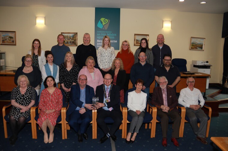 Newry, Mourne and Down District Council Chairperson, Councillor Michael Savage presents Clanrye Group Chief Executive, Liam Devine with an inscribed vase in recognition of the organisations 40 years of service to the local community. Included in the photograph are Deputy Chief Executive Judith Pouches, representative of the Board and staff from the organisation.