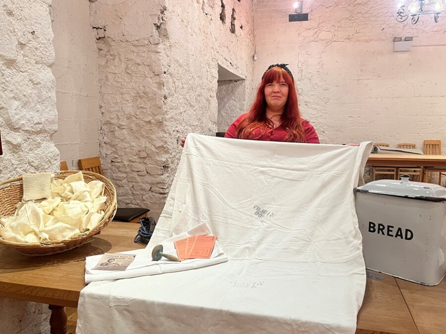 “Mrs. Agnew”, one of the Museum’s living history characters, with the pillowcase and bed sheet donated to the Museum by Rose McKevitt.