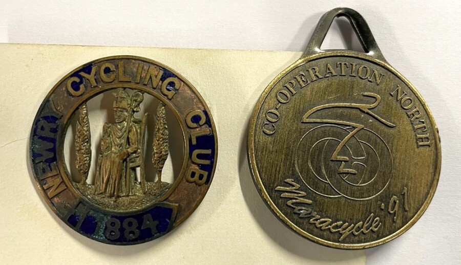 An 1884 members badge for Newry Cycling Club and a 1991 maracycle medal. Newry & Mourne Museum Collection