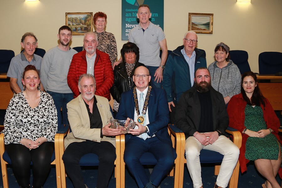Cllr Michael Savage, Chairperson, Newry, Mourne and Down District Council  presents a glass bowl to John O'Hanlon surrounded by family and friends at the civic reception in his honour at Monaghan Row.