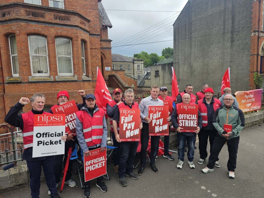 Justin McNulty MLA standing on the picket line with striking school support workers in Newry this week