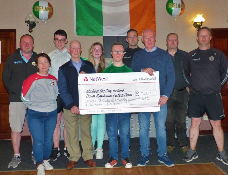 Micheál  receives the cheque for his trip to the Down's syndrome Futsal championship in Italy 