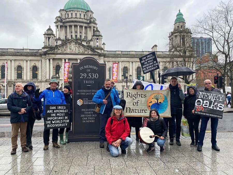 Environmental campaigners outside Belfast City Hall with the memorial to the lost trees.