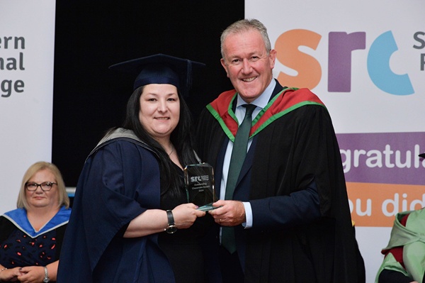 Michelle McParland receiving her Outstanding Classmate Award from Economy Minister Conor Murphy