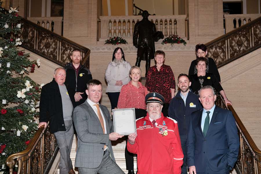 Hospice fundraiser John Dalzell and his team were guests of Justin McNulty, MLA at Stormont to mark their 30th year of fundraising for Southern Area Hospice. John is pictured getting presented with a framed memento from Justin while looking on are Conor Murphy, MLA and Liz Kimmins, MLA. Also included are members of the fundraising team Joe Burns, Steven Henning, Josephine Burns, Joanie Taylor, Mary McCone and Eileen Leonard. Photograph: Columba O'Hare / Newry.ie