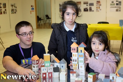 Zaniab and Eshal, pupils from Cloughoge Primary School with Sticky Fingers Volunteer, David Holland at Block City in the Buttercrane Shopping Centre, Part of the Small Size Big Festival. Photograph: Columba O'Hare