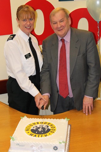 E District Community Safety Sergeant Wendy Walker and Newry and Mourne PCSP Chair, Cllr Andy Moffett cut the cake to celebrate the 100th Neighbourhood Watch Scheme in the local area.