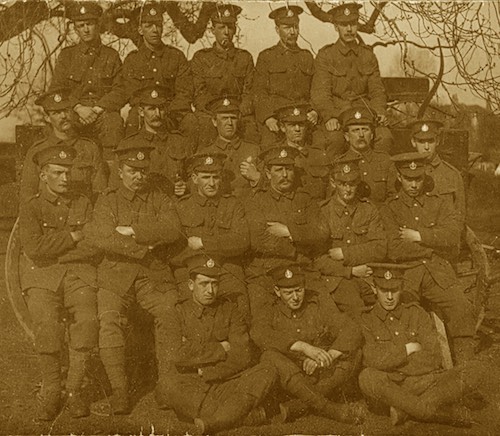 Group of soldiers in Bessbrook, 1915 (Courtesy of Brendan McAllister). On the left hand side in the front row is John McAllister, grandfather of QRadio presenter Kevin McAllister. John is listed in the Newry Roll of Honour and served with the Post Office Rifles during the First World War.