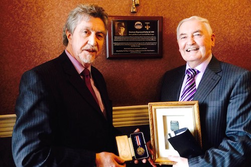 Mickey Brady, MLA is pictured with Willie Kelly a young brother of Raymond’s at the unveiling of the portraits of the two George Cross recipients Mickey Brady, MLA is pictured with Willie Kelly a young brother of Raymond’s at the unveiling of the portraits of the two George Cross recipients