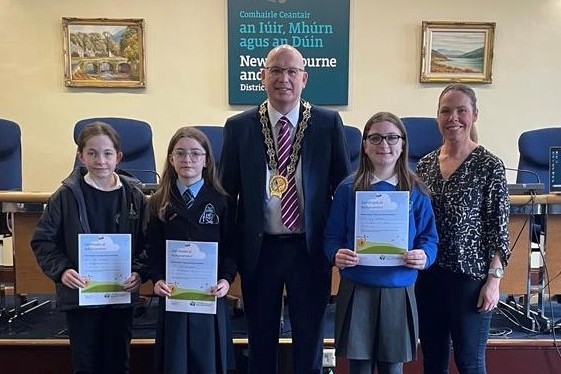 Chairperson, Cllr Michael Savage hosted a prizegiving ceremony at Monaghan Row Civic Centre for the winner and runners up of the Aughnagun honey label design competition. Included from left: Rose McKibbin, Ballyholland PS, Leah Campbell, St Dallan’s PS, Chairperson Cllr Michael Savage, Lily McPolin, St Paul’s PS Cabra and Danielle Begley, NMDDC Biodiversity Officer.