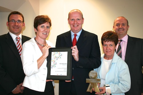 Pictured with their prestigious award on Campus L to R Justin Edwards Director of Curriculum & Student Services, Ann-Marie Hughes Deputy Head of HR, Brian Doran Chief Executive, Janet Little Employee Development & Equality Manager and Raymond Sloan Head of HR & Development.