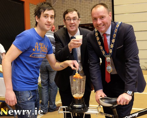 JJ Gilmore, Action Renewables demonstrating their bicycle powered smoothie maker at the Sustainable Living Fair to Mayor Michael Ruane and Kevin Scullion, Assistant Director Environment, Health and Building Services, Newry and Mourne District Council. Photograph: Columba O'Hare