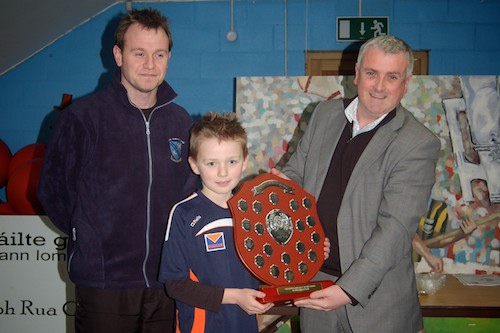 Under Ten Craobh Rua player Niall Elshaw receiving the Richard Hughes memorial plaque from St.Josephs PS teacher, Michael Doran and Colin Kavanagh from club sponsors The Quays.